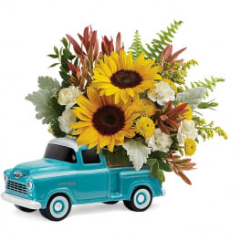 Sunflowers arranged in a turquoise toy pickup truck