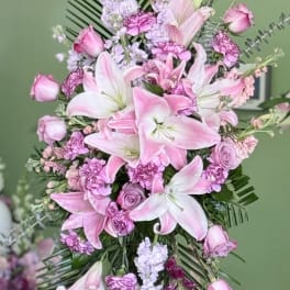 Pink lilies and roses arranged on a standing easel
