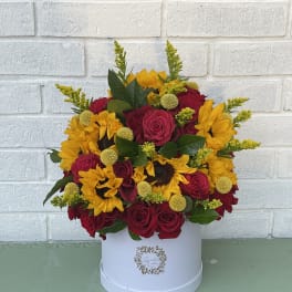 Red roses and yellow sunflowers in a white hat box