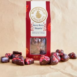 Box of berry chocolate hearts with pieces scattered around it