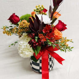 Mixed bouquet in a checkered vase with a red ribbon