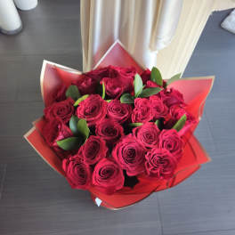 Hand-tied bouquet of red roses wrapped in red paper