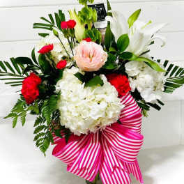 Bouquet of white lilies, hydrangeas, and red carnations with a pink striped ribbon
