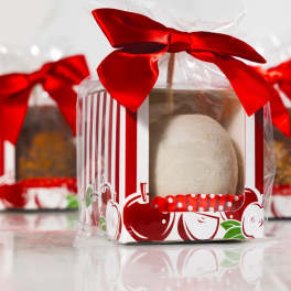 Three wrapped gift boxes with red bows and round treats inside