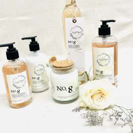 Soap bottles and a candle with a white rose