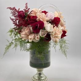 Bouquet of red, blush, and cream roses in a glass vase