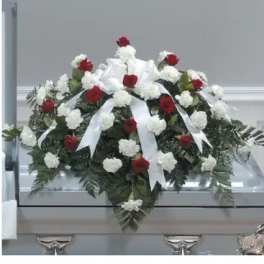 Red and white floral casket spray with ribbon