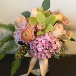 Bouquet of pastel roses, hydrangea, and green orchids with ribbon