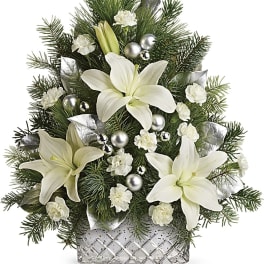 White lilies and carnations in a glass vase with pine and silver ornaments
