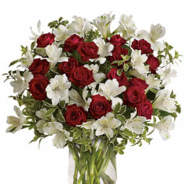 Bouquet of red roses and white alstroemeria in a clear glass vase