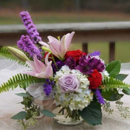 Bouquet of lilies, roses, and purple flowers with greenery