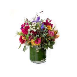 Mixed bouquet in a clear glass vase with pink, purple, and yellow flowers