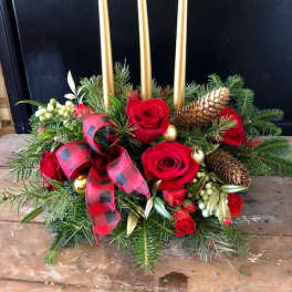 Holiday centerpiece with red roses, gold candles, and pinecones