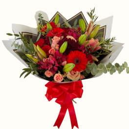 Bouquet of red and pink flowers wrapped with black paper and a red ribbon