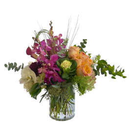 Mixed bouquet of orchids and roses in a glass vase