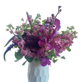 Purple mixed bouquet in a light blue vase