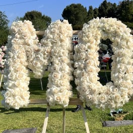 Large white rose floral display spelling a word on easels outdoors