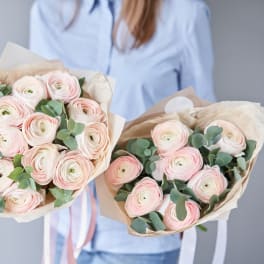 Two bouquets of pale pink ranunculus wrapped in paper