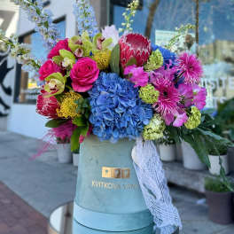 Colorful bouquet in a blue hatbox with lace ribbon