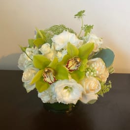 White and green floral arrangement in a glass vase
