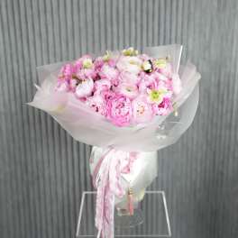 Pink bouquet of peonies wrapped in white paper with ribbon