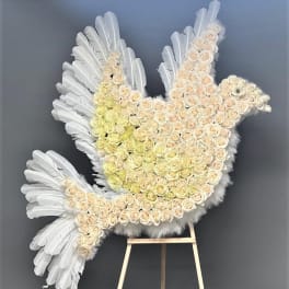 White feathered dove-shaped floral tribute on an easel