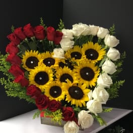 Heart-shaped arrangement of red and white roses with sunflowers