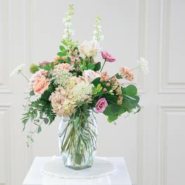 Pastel mixed flower arrangement in a clear glass vase