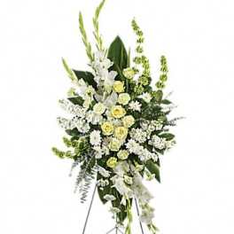 Tall white and pale yellow funeral spray on a standing easel