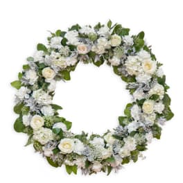 Round floral wreath with white roses and mixed white blooms