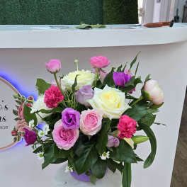 Mixed bouquet of pink, purple, and white flowers in a vase