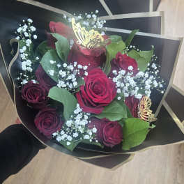 Bouquet of red roses with baby's breath in black wrap