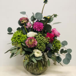 Mixed pink and white flowers in a round glass vase
