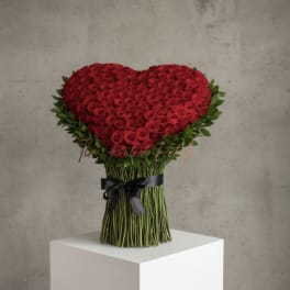 Heart-shaped bouquet of red roses with a black ribbon