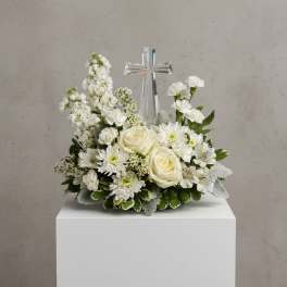White floral arrangement with a clear cross centerpiece