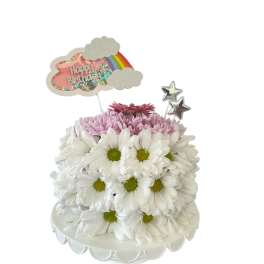 White daisy cake with pink flowers and birthday topper