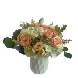 Peach and white rose bouquet in a white vase
