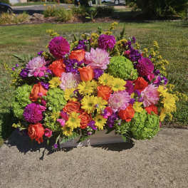 Colorful mixed flower arrangement in a rectangular container outdoors