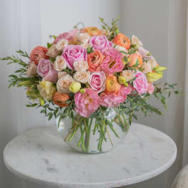 Pink and peach rose bouquet in a clear glass vase
