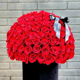 Large bouquet of red roses in a black hatbox with ribbon