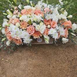 Large peach and white floral arrangement in a wooden container