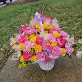 Pink and yellow flower basket with butterfly picks in a white basket