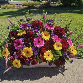 Bright mixed flower arrangement in a low rectangular container