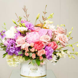 Mixed pink, purple, and white bouquet in a white vase