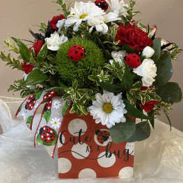Bouquet of red and white flowers in a decorated gift box with ladybug accents