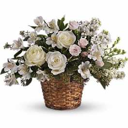 White roses and small white flowers in a woven basket