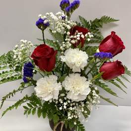Bouquet of red roses and white carnations in a dark vase