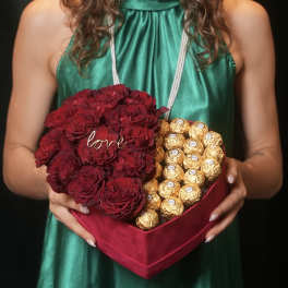 Heart-shaped box with red roses and gold-wrapped chocolates