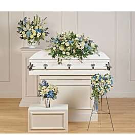 White casket with blue and white floral sprays