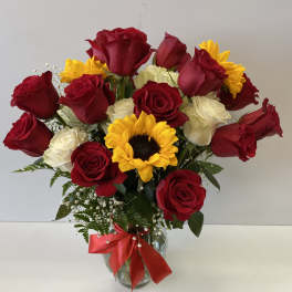 Bouquet of red and white roses with a sunflower in a glass vase